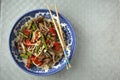 Saute vegetables in a blue bowl with chopsticks