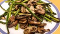 Sauteed asparagus and sliced mushrooms with rosemary on plate