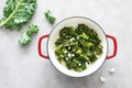 Sauteed kale with garlic in cast iron pan on kitchen table, healthy food concept, superfood Royalty Free Stock Photo