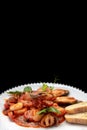 Sauteed seafood on a white plate, with toasts on a dark background Royalty Free Stock Photo