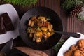 Sauteed sweet potato salad on black bowl on brown wooden background. Side dish for christmas, thanksgiving, and new year's eve din