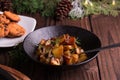 Sauteed sweet potato salad on black bowl on brown wooden background. Side dish for christmas, thanksgiving, and new year's eve din