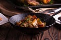 Sauteed sweet potato salad on black bowl on brown wooden background. Side dish for christmas, thanksgiving, and new year's eve din