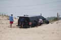 Savage Ditch, Delaware, U.S - August 5, 2023 - A group of men digging a black truck that was stuck on the sand