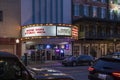 The Savannah Taphouse with a marquee in lights and neon signs in the window surrounded by shops and restaurants with cars