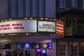 The Savannah Taphouse with a marquee in lights and neon signs in the window surrounded by shops and restaurants at sunset