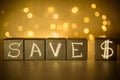 Save $ chalk written on black cubes on blurred bokeh background