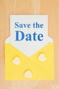 Save the Date message on white card and hearts with a yellow envelope