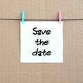 Save the date. Note is written on a white sticker that hangs wit Royalty Free Stock Photo