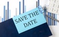 SAVE THE DATE on sticky note on notebook on the chart background Royalty Free Stock Photo