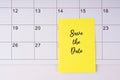 Save the date text on adhesive note on calendar Royalty Free Stock Photo