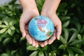 Save The Earth and Care Environment Concept, Close-up of Woman Hands is Holding Mockup Global Against on Tree Leave Background. Royalty Free Stock Photo