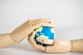 Save Earth Concept. Closeup of wooden hand holding mini world ball on white bakcgorund