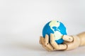 Save Earth Concept. Closeup of wooden hand holding mini world ball on white bakcgorund