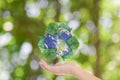 Hands with Earth and recycle logo over green nature background Royalty Free Stock Photo