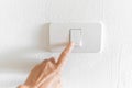 Save electricity Close up of finger is turning on or off on light switch on grunge concrete wall. elderly woman hand with Royalty Free Stock Photo