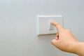 Save electricity Close up of finger is turning on or off on light switch. woman hand with finger on light switch Copy space.