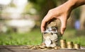 Save money concept hands  holding coins placed  on gold coins at a level different from financial  investing coins outside the Royalty Free Stock Photo