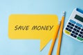 Save money inscription on yellow speech bubble, blue background. Financial concept, savings