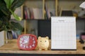 Save Money and Planning concept. Organizer, planner book, Desktop calendar, clock, and piggy bank placed on wooden desk. Save Royalty Free Stock Photo