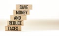 SAVE MONEY AND REDUCE TAXES text on wooden blocks and white background.