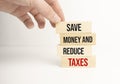 SAVE MONEY AND REDUCE TAXES text on wooden blocks and white background. Smart - Saving money and tax cuts acronym in business