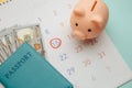 Save money for travelling. Piggy bank and passport with money on calendar Royalty Free Stock Photo