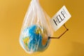 Save our planet concept Earth in a plastic bag holds card with inscription help Royalty Free Stock Photo