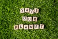 Save our planet words, message written on wooden blocks over green grass, top view. Save planet, climate changes concept Royalty Free Stock Photo