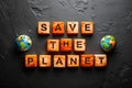Save the Planet message on dark stone, globes Royalty Free Stock Photo