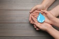 Save Water concept. Man and woman holding paper drop at wooden table, top view with space for text Royalty Free Stock Photo