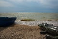 Saver boat and big inflatable toy crocodile shape lie in front of sea on beach line. Royalty Free Stock Photo