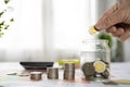 Saving coins, money. Hand of business man putting coins in glass bottle with stack coin Royalty Free Stock Photo