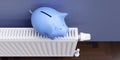 Saving on energy cost in winter. Piggy bank on heating radiator, blue wall background