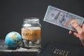 Saving jars full of money and globe with Holy Bible for mission, Mission christian idea. Hand holding dollar with bible on wooden Royalty Free Stock Photo