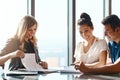 Saving a little goes a long way. a young couple meeting with a financial planner in a modern office.