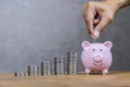 Saving, male hand putting a coin into piggy bank