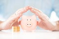 Saving money. Accounting, business, budget and finance concept. Male hands above piggy bank near coins stack Royalty Free Stock Photo