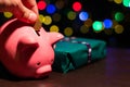 Saving money for Christmas present. Holiday piggy bank with colourful bokeh balls in the background