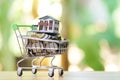 Saving money concept of collecting coins Thai money in a Shopping Cart and house model on nature background. as background busi