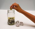 Saving Money Concept With Hand Putting A Coins On Glass Jar.Selective Focus And Shallow DOF.