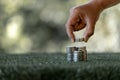 Saving money concept preset by female hand putting money coin stack growing business. Asian woman making stack of coin, planning Royalty Free Stock Photo