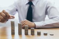 Saving money concept preset, the young man arranged the coins like a graph of the growing business Royalty Free Stock Photo