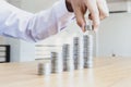 Saving money concept preset, the young man arranged the coins like a graph of the growing business Royalty Free Stock Photo