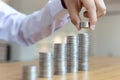 Saving money concept preset, the young man arranged the coins like a graph of the growing business Royalty Free Stock Photo