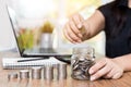 Saving money and finances concept, Close up hand woman hand put coins in jug glass with Calculate with calculator Royalty Free Stock Photo