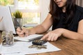 Saving money and finances concept, Close up hand woman hand put coins in jug glass with Calculate with a calculator Royalty Free Stock Photo