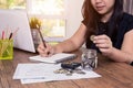 Saving money and finances concept, Close up hand woman hand put coins in jug glass with Calculate with a calculator Royalty Free Stock Photo