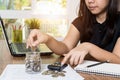 Saving money and finances concept, Close up hand woman hand put coins in jug glass with Calculate with a calculator Royalty Free Stock Photo