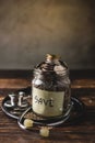 Saving money and coins in a glass bottle on a wooden floor. Investment concept for the future. With bokeh background